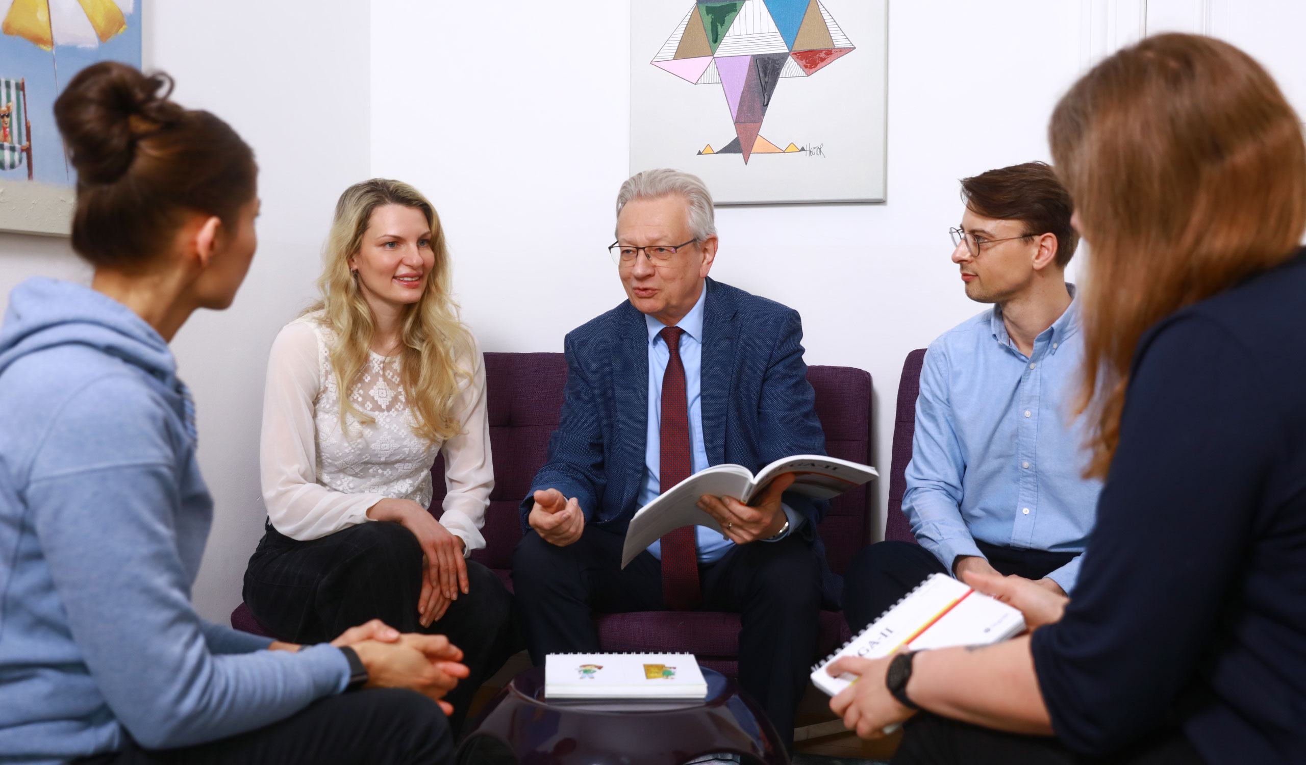 Gruppenfoto von Prof. Esser und einem Teil seines Therapeutenteams in einer Besprechung